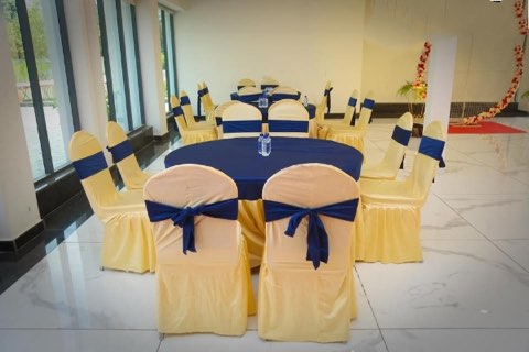 Round dining tables set by the windows of the banquet hall