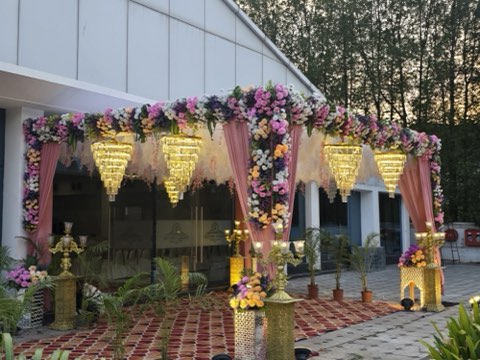 Floral entrance canopy with hanging chandeliers outside the hall by day