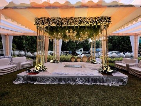 Draped canopy mandap on the lawn with sofa seating for guests
