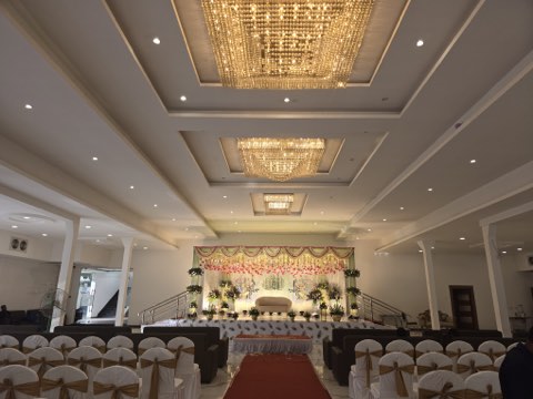 Main hall (Hall 1) with crystal chandeliers, guest seating and a floral wedding stage at Jaithri Grand Convention, Shamshabad