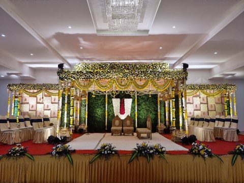 Floral canopy wedding mandap under a crystal chandelier in the banquet hall on Airport Road, Hyderabad
