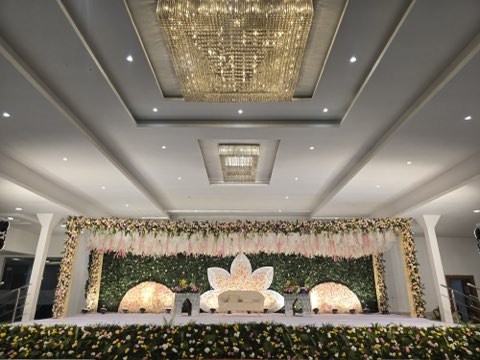 Pastel floral wedding stage with white sofa and lotus backdrop under the chandelier in Hall 1