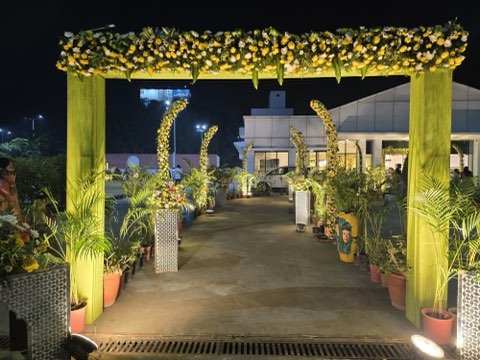 Yellow floral entrance arch and lit pathway to the convention hall at night